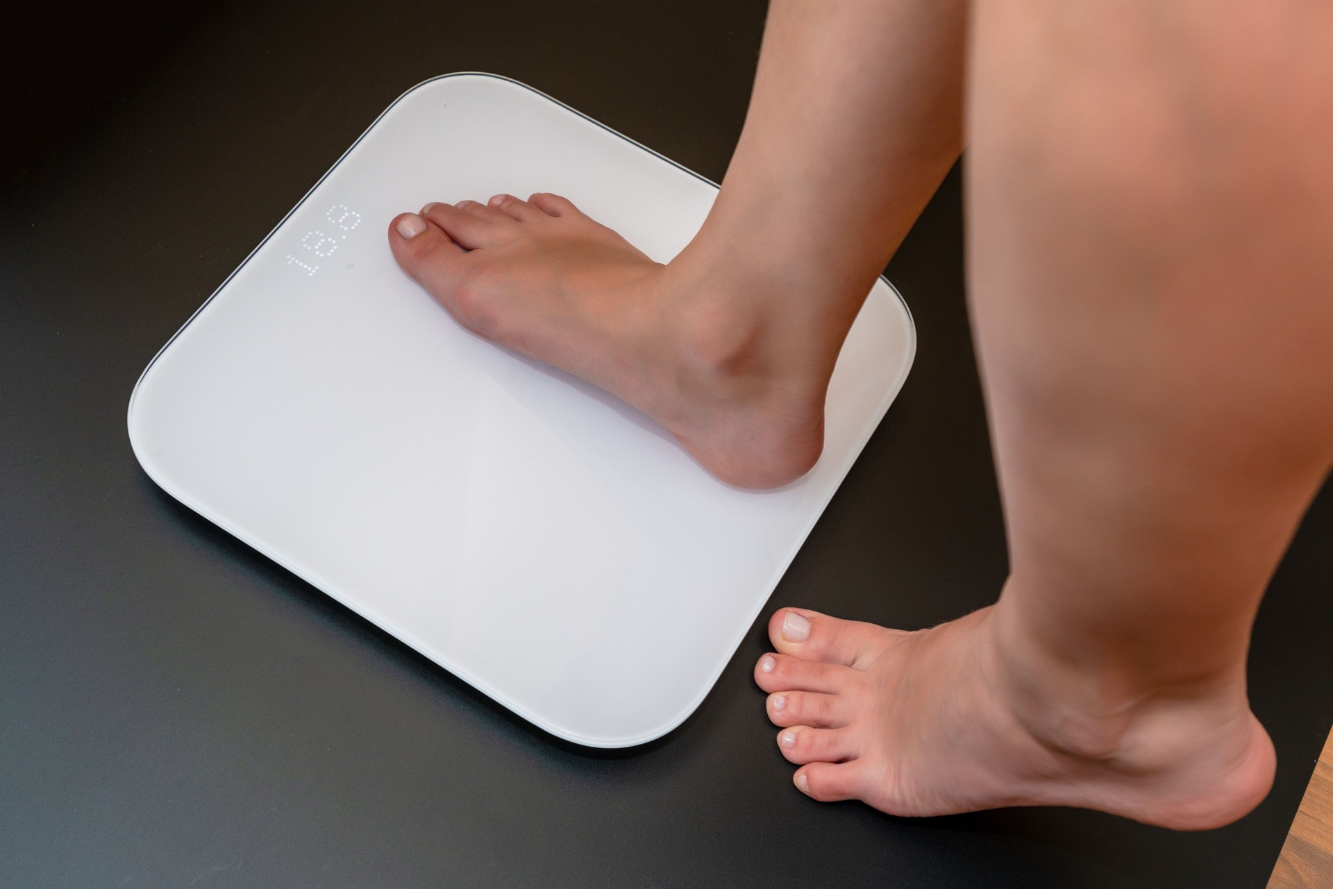 Woman's feet standing on electronic scales for diet control