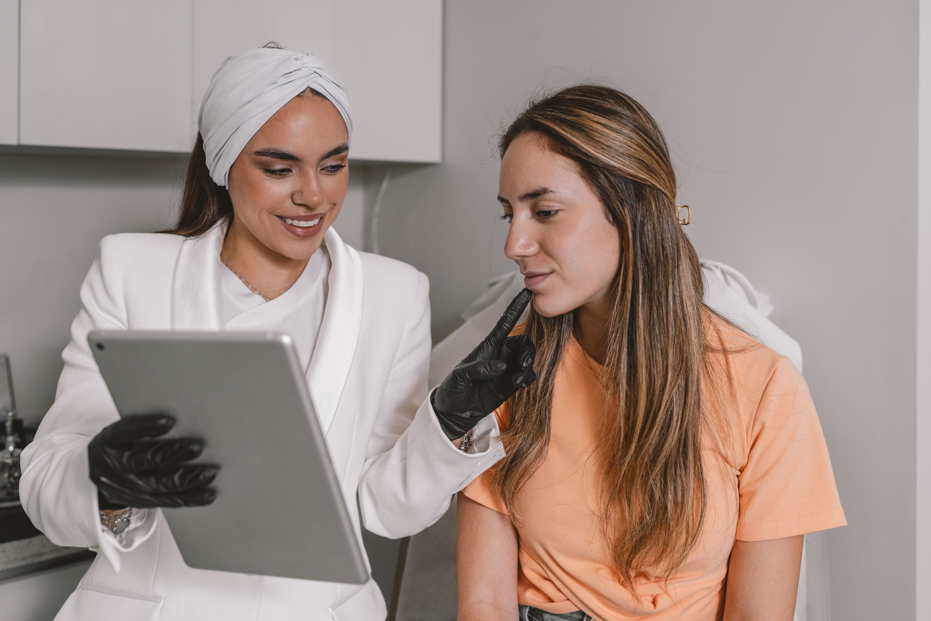 Esthetician explaining a Botox intervention using a digital tablet