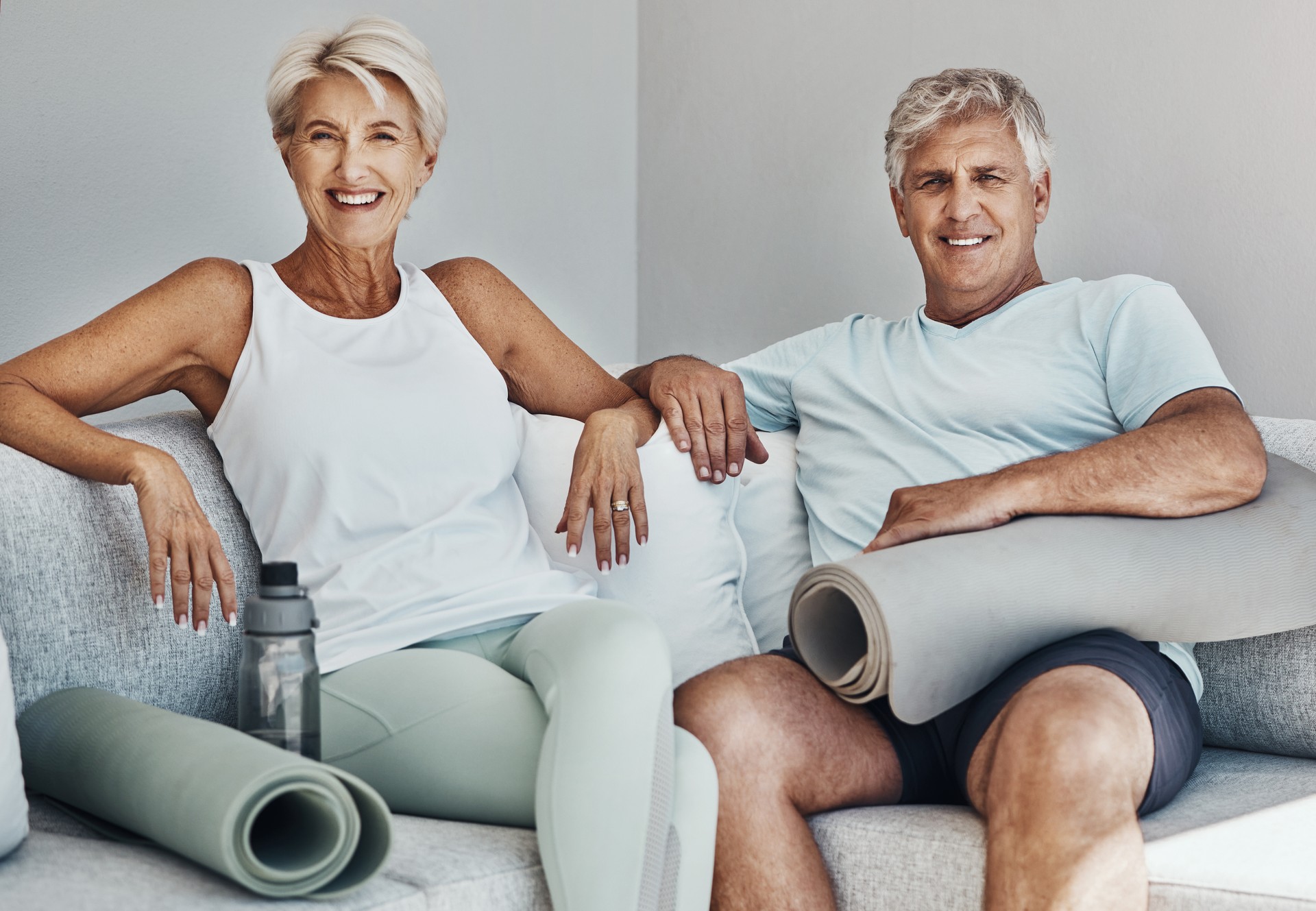 Active senior couple smiling after a yoga session, promoting longevity and wellness at Rewind Time event.