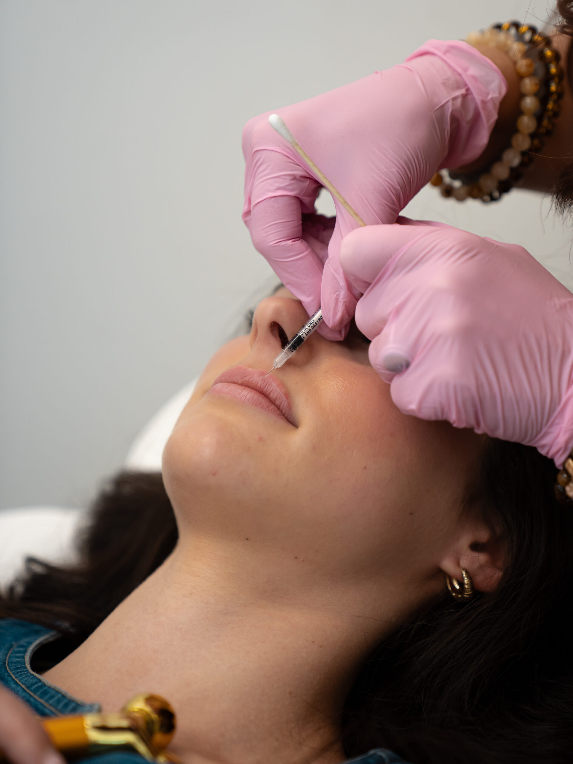Laura McDonald, MSN, APRN, FNP-BC administering lip filler to a client at Rewind Time Anti-Aging & Aesthetics in Lenexa, KS