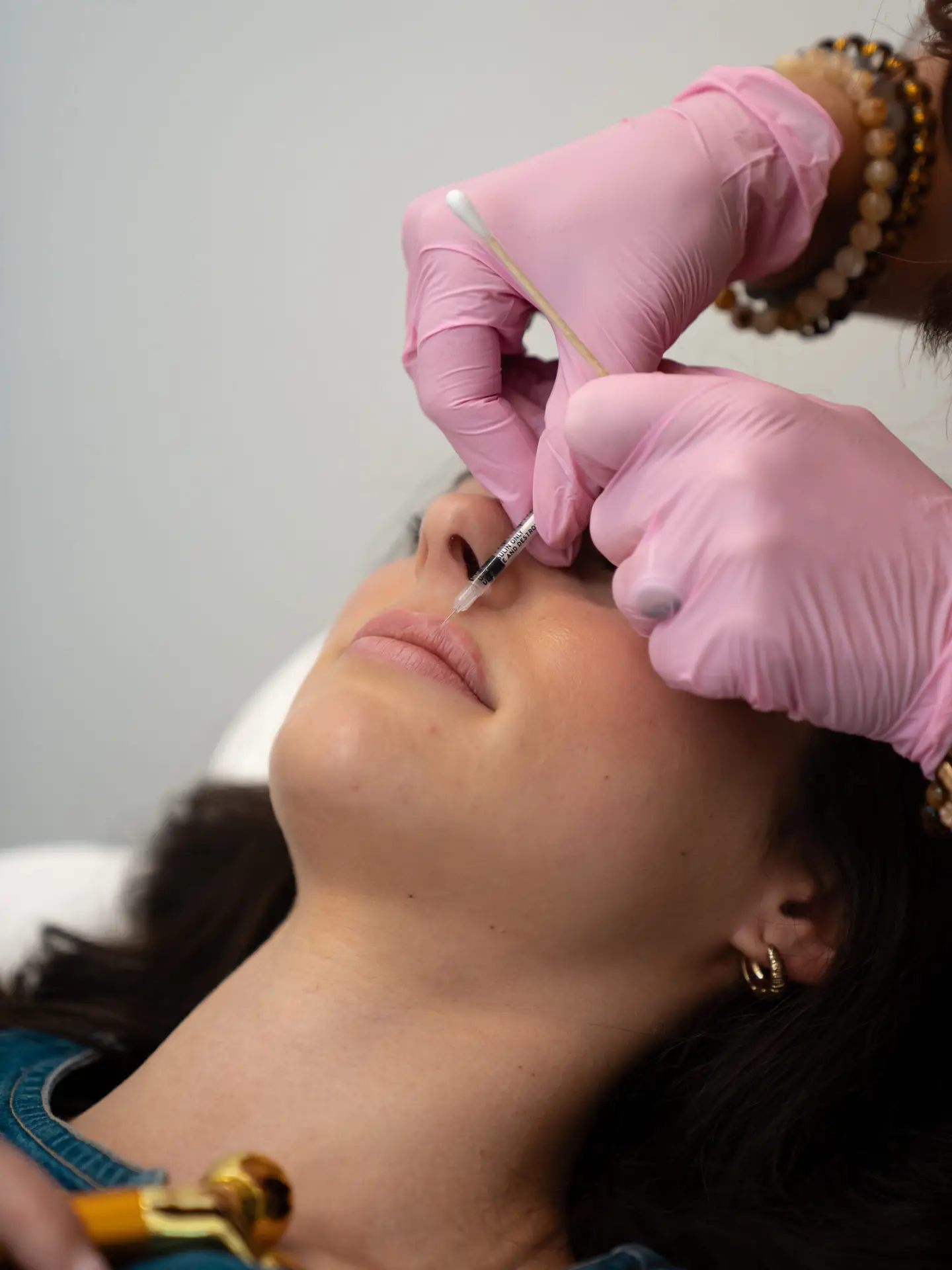 Laura McDonald, MSN, APRN, FNP-BC administering lip filler to a client at Rewind Time Anti-Aging & Aesthetics in Lenexa, KS